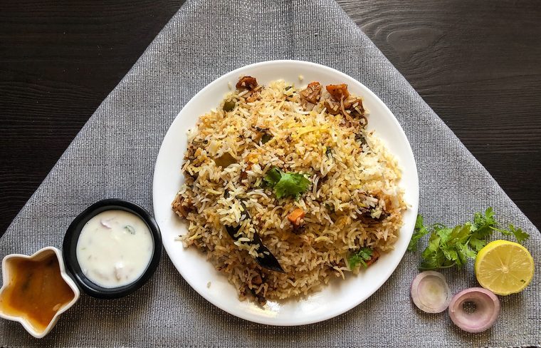 A plate of Hyderabadi dum biryani served with garnish